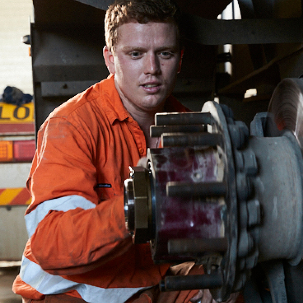 A mechanic servicing a Freightliner truck