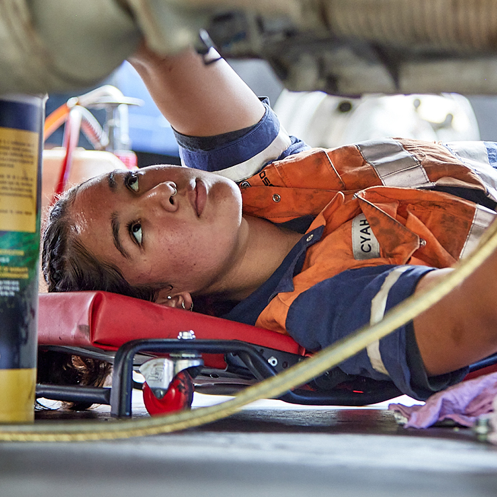 A mechanic servicing a Fuso truck