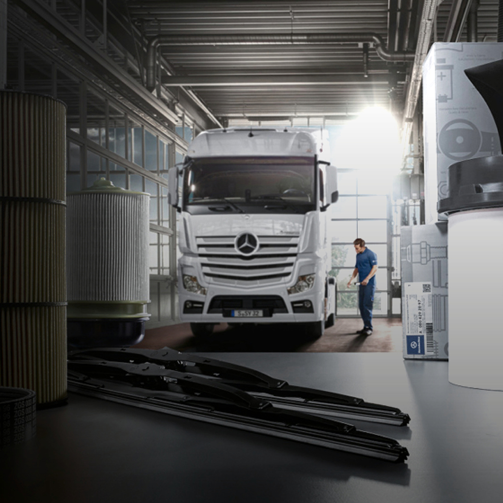 A white Mercedes-Benz truck parked in a mechanics workshop