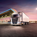 A white Fuso Shogun truck parked in a petrol station at dusk