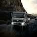 A dark Mercedes-Benz Arocs truck with bright headlights